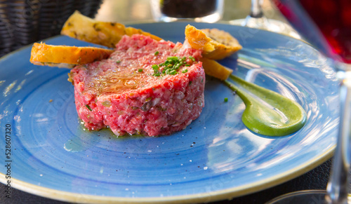 Foto Image of delicious veal steak tartar served at plate with fried bread, food on c