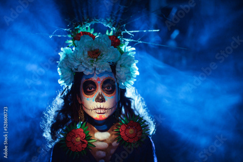 Fototapeta Naklejka Na Ścianę i Meble -  Woman with mexican skull halloween makeup on face. Day of the dead aka Dia de los Muertos and halloween party concept.