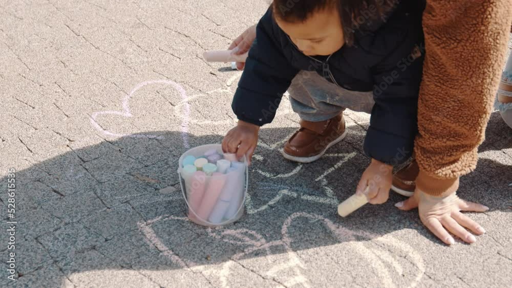 Afro-American little boy drawing by a chalk woth his mother at a playground, outdoors motherhood concept. High quality 4k footage Afro-American little boy drawing by a chalk woth his mother at a playground, outdoors motherhood concept. High quality 4k footage
