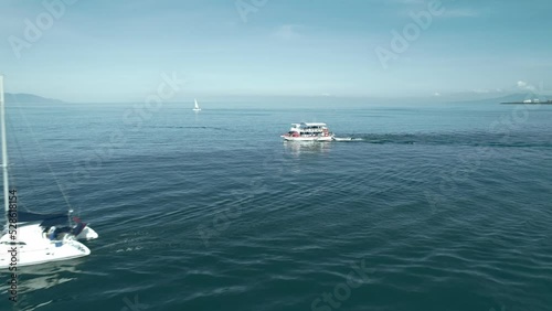 drone shot of fishing boats going out to fish in a sunny morning at puerto vallarta mexico next to the hotel zone beach photo