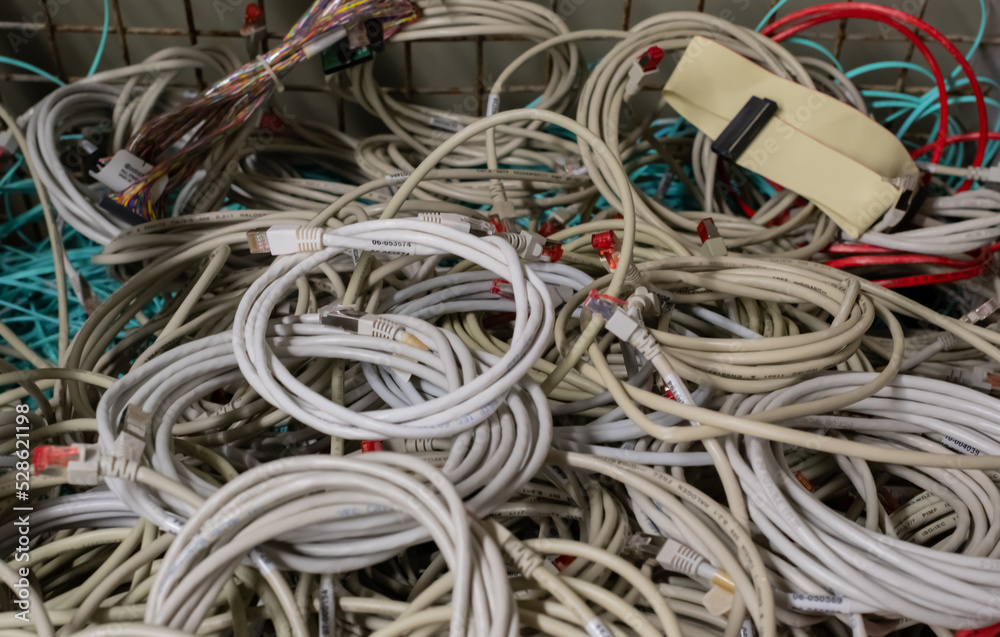 Alte Netzwerkkabel und Stromkabel in einer Gitterbox zur Entsorgung gelagert Alte Netzwerkkabel und Stromkabel in einer Gitterbox zur Entsorgung gelagert