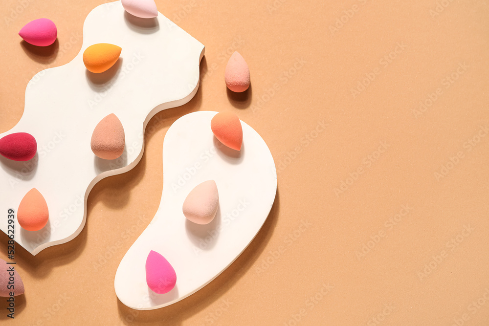Stands with makeup sponges on beige background Stands with makeup sponges on beige background