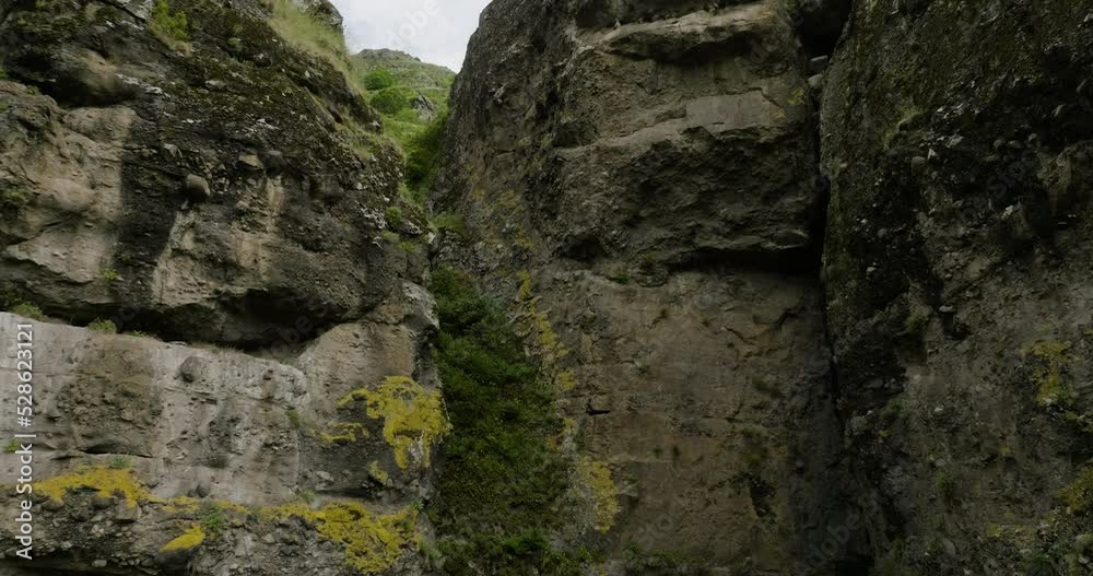 Massive Mossy Cliffs At Vanis Kvabebi Cave Town In Samtskhe-Javakheti Region Of Georgia. Aerial Approach Massive Mossy Cliffs At Vanis Kvabebi Cave Town In Samtskhe-Javakheti Region Of Georgia. Aerial Approach