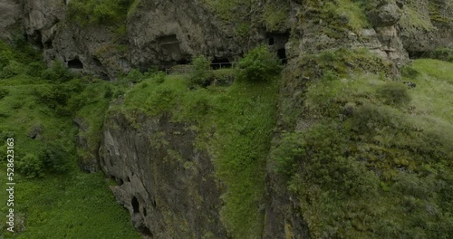 Remains Of Vanis Kvabebi Cave Monastery In Rough Cliff, Samtskhe-Javakheti Region Of Georgia. aerial drone tilt-up photo