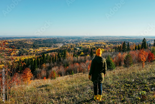 Young woman standing in mountain, autumn landscape.