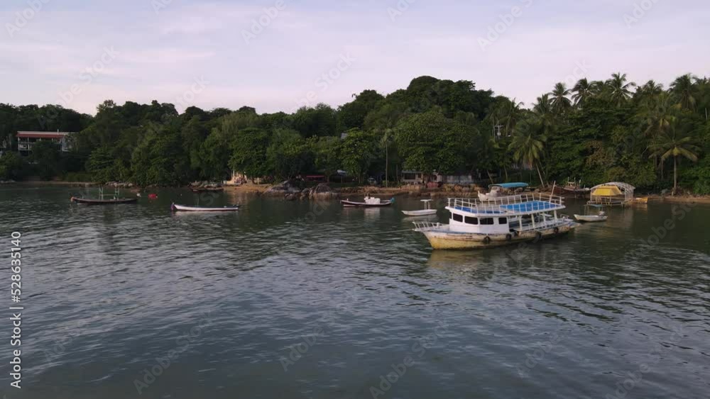 Drone aerial slow move backwards with Thai boats over tropical blue water Drone aerial slow move backwards with Thai boats over tropical blue water