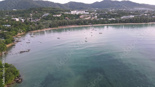 Drone aerial slow pan down to tropical blue water to Thai boats photo