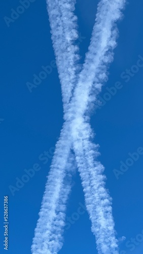 Kondensstreifen am wolkenlosen Himmel ergeben eine Form die aussieht wie ein X.
contrails, Wolken, chemtrails, clouds, Chemikalienstreifen