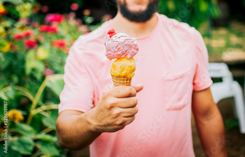 Unrecognizable people holding ice cream in cone outdoors. Front view of person hands holding an ice cream cone. People showing a double ice cream cone. Cone ball ice cream concept