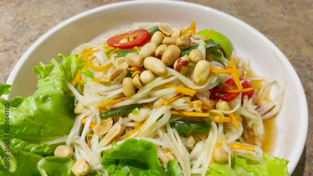 Thai Green Papaya salad. Traditional Thai food papaya salad prepared with fine slices of papaya, tomatoes, green beans and peanuts Thai Green Papaya salad. Traditional Thai food papaya salad prepared with fine slices of papaya, tomatoes, green beans and peanuts