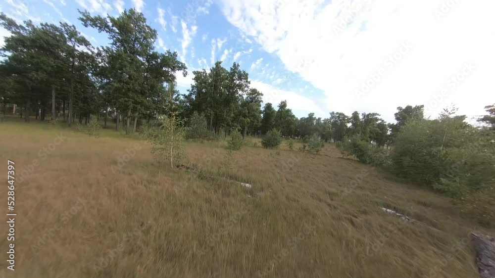 fpv drone flight in oak grove, forest, summer in sunny weather, blue sky, green foliage, motocross bike, motorcyclist, field, grass fpv drone flight in oak grove, forest, summer in sunny weather, blue sky, green foliage, motocross bike, motorcyclist, field, grass