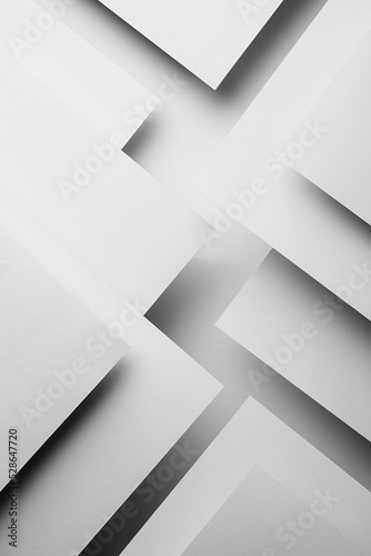 White abstract geometric background with fly white surfaces as monochrome stylish pattern with triangles, corners, inclined stripes, lines and shadows in elegant simple modern minimal style, vertical.