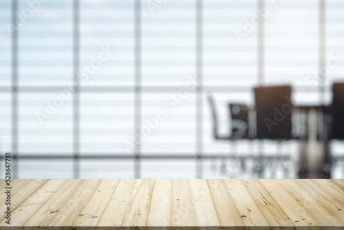 Empty wooden office table with light sunny furnished conference room with large window on background, mockup © Pixels Hunter