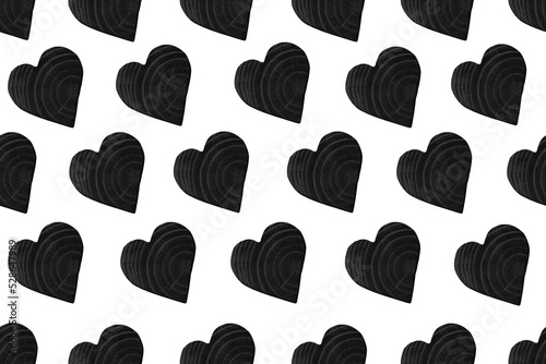 Seamless pattern from black wooden heart. Decorative background from a wooden heart.