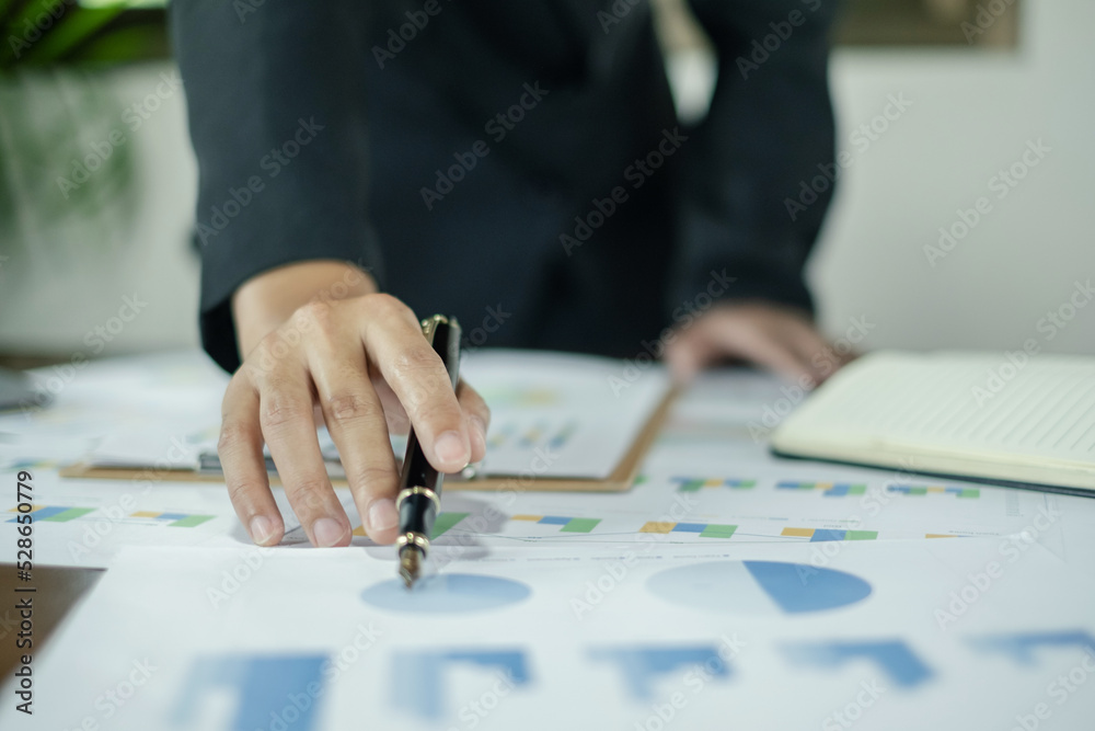 Asian female accountants sit at their desks and calculate financial graphs showing results about their investments, planning a successful business growth process Asian female accountants sit at their desks and calculate financial graphs showing results about their investments, planning a successful business growth process
