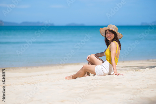 Wallpaper Mural Woman tourist in yellow swimsuit and hat, happy traveler sunbathing at Paradise beach on Islands. destination, wanderlust, Asia Travel, tropical summer, vacation and holiday concept Torontodigital.ca