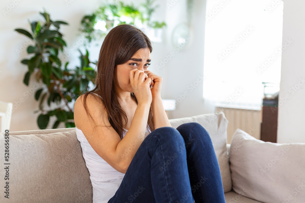 Unhappy young woman covering face with hands, crying alone close up, depressed girl sitting on couch at home, health problem or thinking about bad relationships, break up with boyfriend, divorce Unhappy young woman covering face with hands, crying alone close up, depressed girl sitting on couch at home, health problem or thinking about bad relationships, break up with boyfriend, divorce