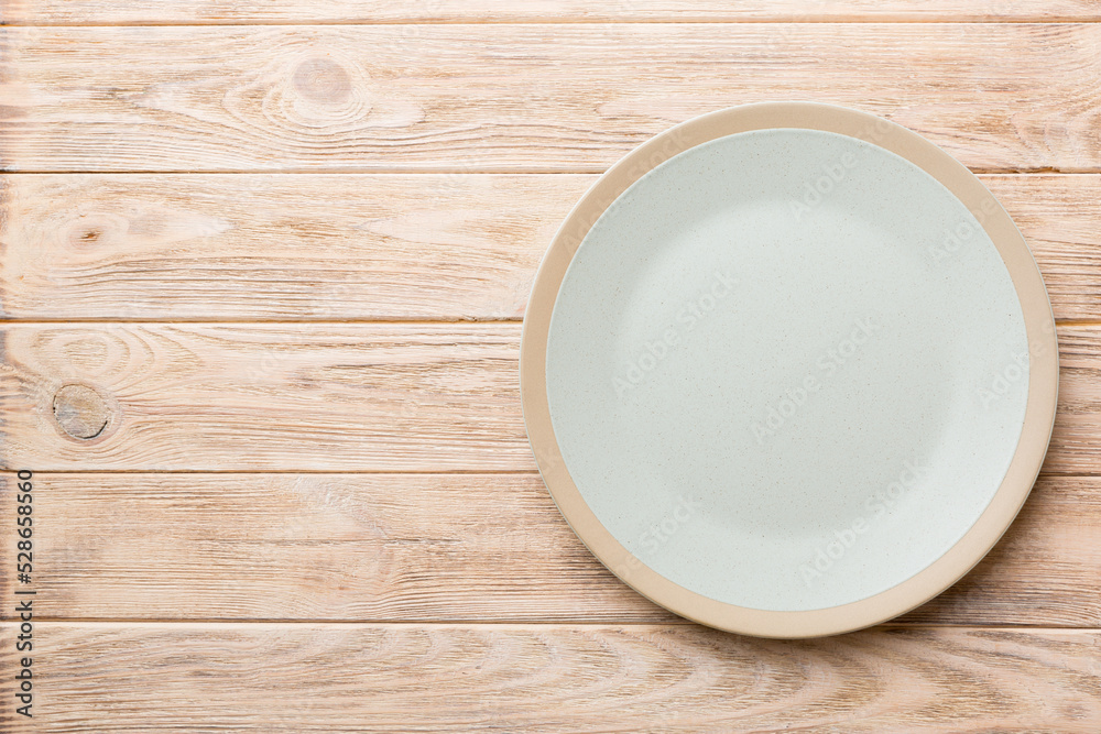 Top view of empty light plate on wooden background. Empty space for your design Top view of empty light plate on wooden background. Empty space for your design
