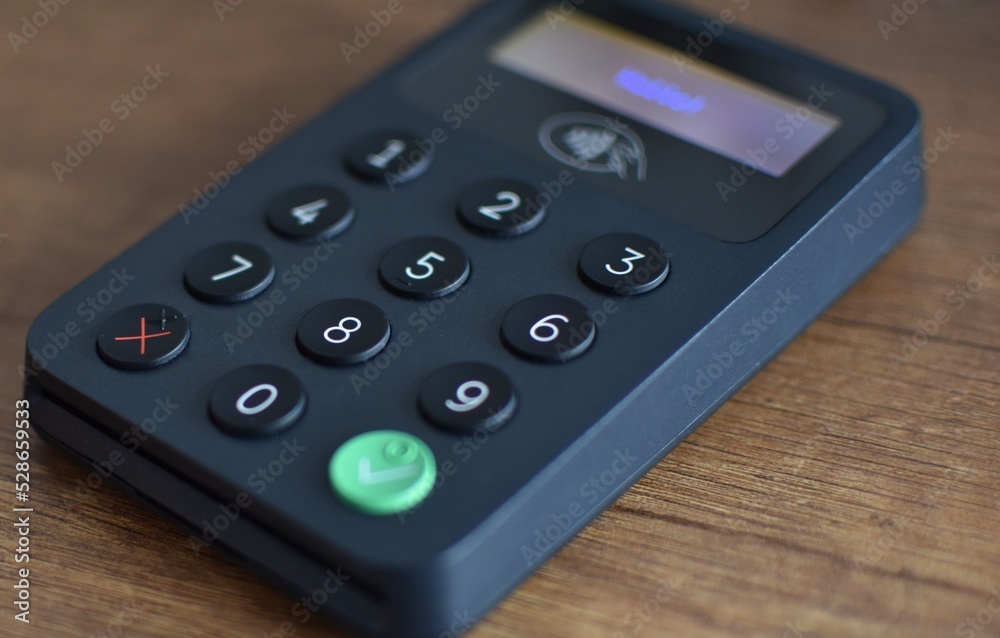 contactless terminal for plastic cards on a wooden brown table