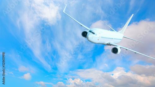 White passenger airplane flying in the sky amazing clouds in the background - Travel by air transport