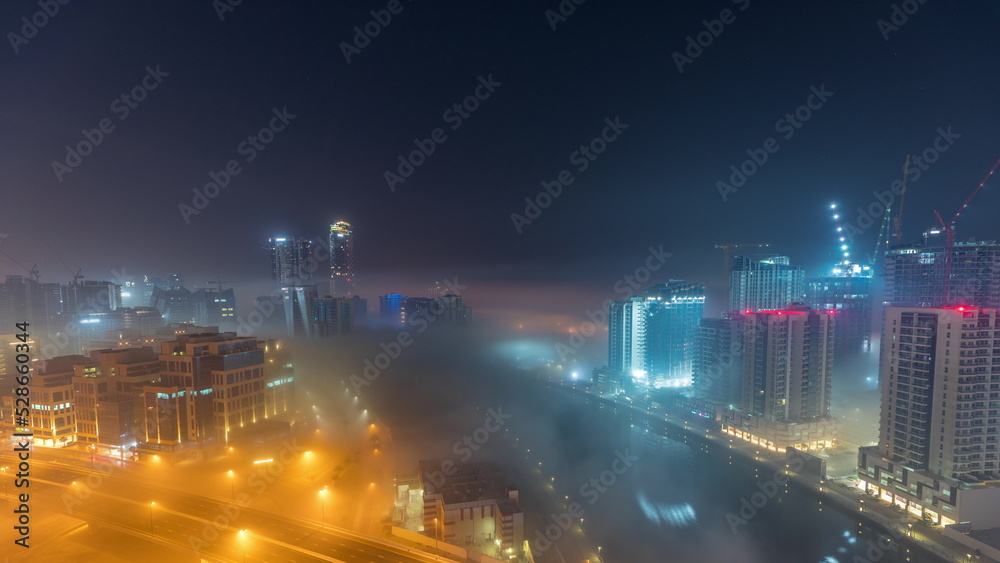Buildings are covered in thick layer of fog in Business Bay night timelapse. Buildings are covered in thick layer of fog in Business Bay night timelapse.
