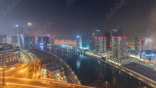 Modern city architecture in Business bay district before sunrise. Panoramic view of Dubai's skyscrapers all night timelapse