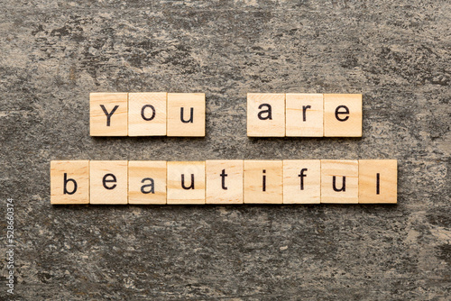 You are beautiful word written on wood block. You are beautiful text on cement table for your desing, Top view concept