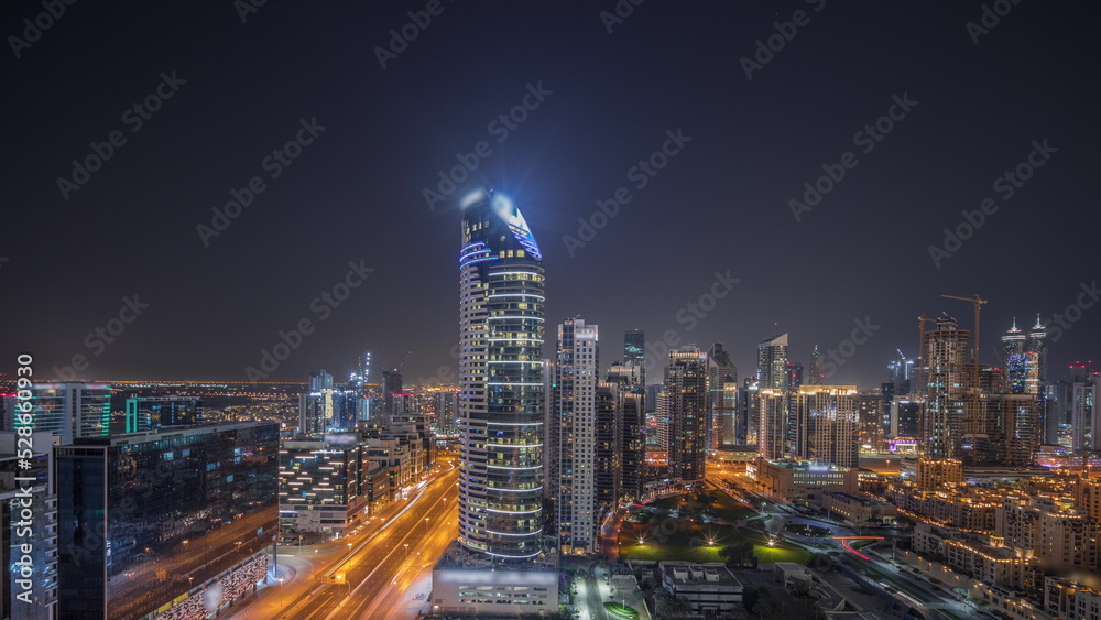 Obraz premium Panorama showing Dubai's business bay towers aerial night timelapse. Rooftop view of some skyscrapers