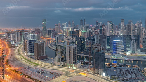 Skyline with modern architecture of Dubai business bay towers night to day timelapse. Aerial view