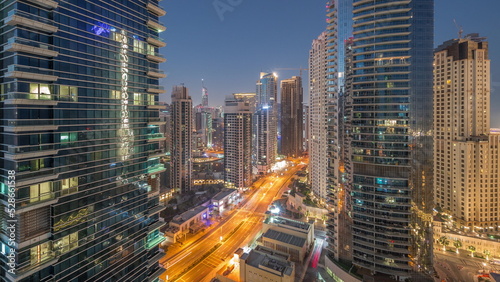 View of the Dubai Marina and JBR area and the famous Ferris Wheel aerial night to day timelapse