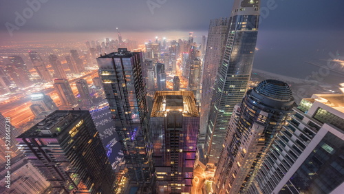 Skyline panoramic view of Dubai Marina showing canal surrounded by skyscrapers along shoreline night to day timelapse. DUBAI, UAE