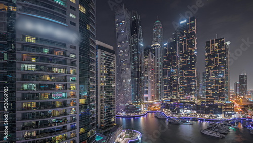 Panorama showing Dubai marina tallest skyscrapers and yachts in harbor aerial night timelapse. #528661923