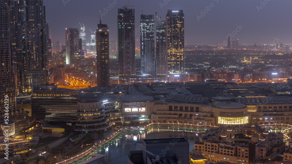 Obraz premium Dubai downtown with fountains and modern futuristic architecture aerial night to day timelapse