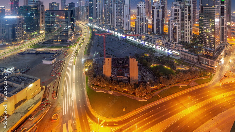 Obraz premium Bay Avenue with modern towers residential development in Business Bay aerial panoramic night to day timelapse, Dubai