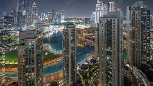 Panorama showing Dubai Downtown cityscape with tallest skyscrapers around aerial night timelapse.