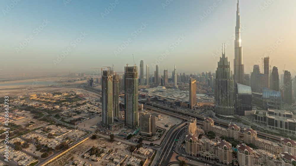 Panorama showing aerial view of tallest towers in Dubai Downtown skyline and highway timelapse.