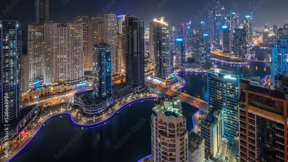 Fototapeta premium View of various skyscrapers in tallest recidential block in Dubai Marina aerial night timelapse