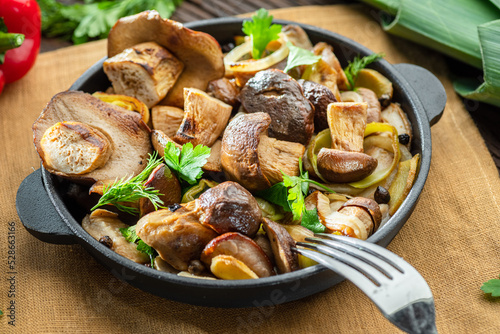 Obraz na plátne Cooked porcini mushrooms in the frying pan on the wooden table.