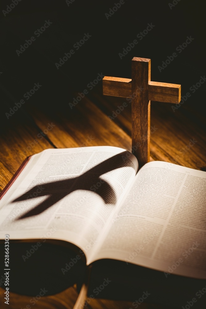 Cross with shadow falling on bible Cross with shadow falling on bible
