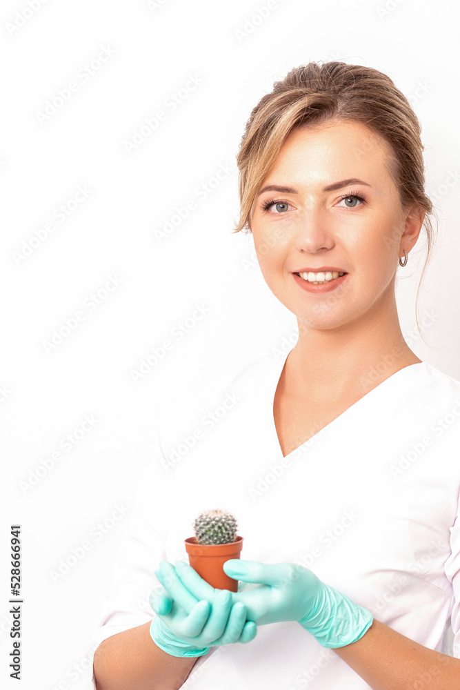 A portrait of a smiling female holds little green cactus in her hands. Hair removal concept A portrait of a smiling female holds little green cactus in her hands. Hair removal concept