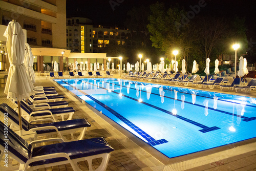 Evening poolside in luxury hotel. swimmingpool with sun beds and umbrellas