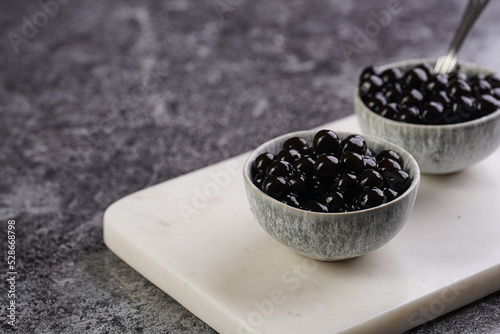 Φωτογραφία Cooked tapioca pearls for trendy bubble boba ice tea in two small grey ceramic b