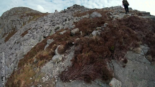 Abstract view of a man hiking down a steep brown mountain  photo