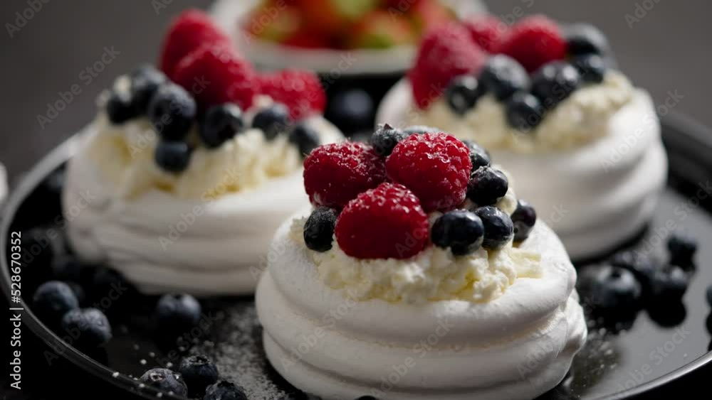 Delicious mini pavlova meringue desserts served with frozen frosty berries Delicious mini pavlova meringue desserts served with frozen frosty berries