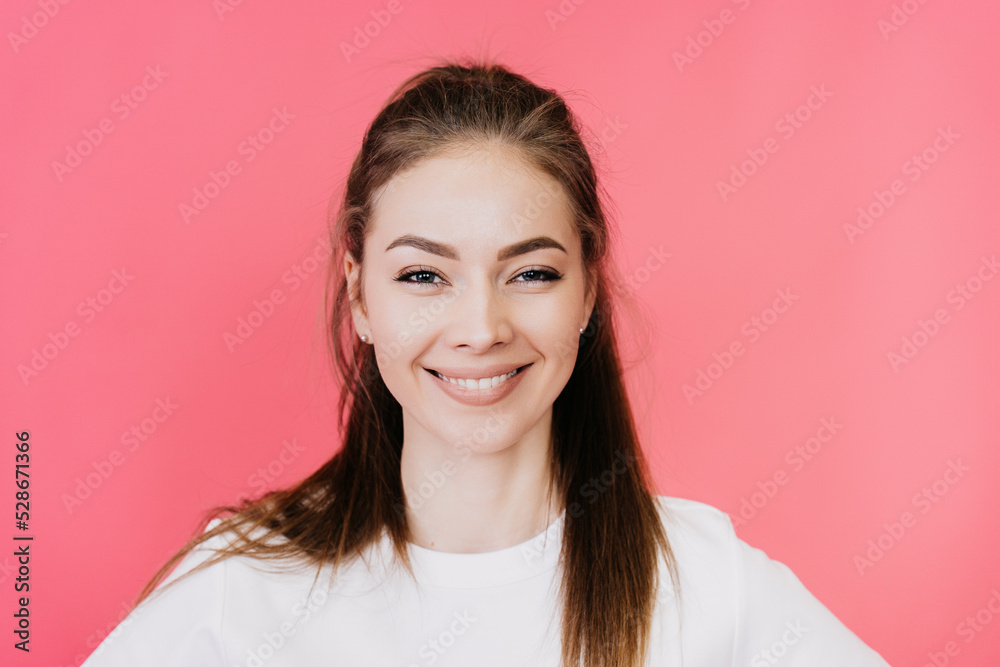 Close up portrait of a young beautiful girl, smiling, looking at the camera in a white T-shirt on a pink background. Mockup of happy people, portraits. Happy Italian model in love. Close up portrait of a young beautiful girl, smiling, looking at the camera in a white T-shirt on a pink background. Mockup of happy people, portraits. Happy Italian model in love.