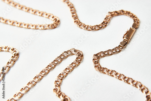 Gold chain on a white background with copy space