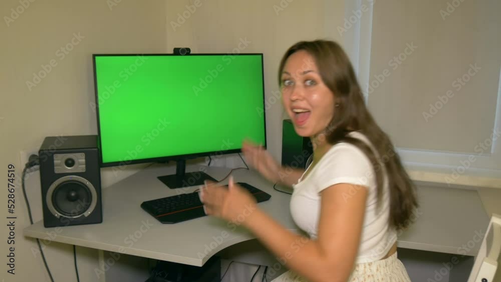 Girl is very happy with what is shown on the computer screen. Chromakey on computer screen. Video with a chroma key on the screen to insert any video or image. Girl is very happy with what is shown on the computer screen. Chromakey on computer screen. Video with a chroma key on the screen to insert any video or image.