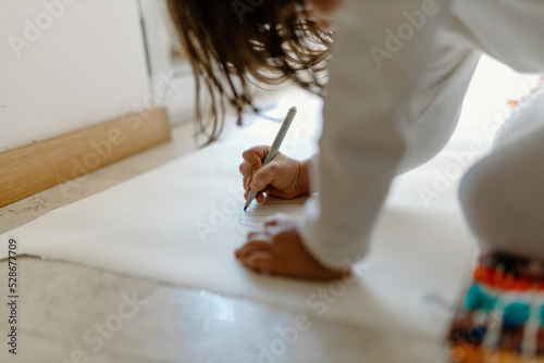 Clute girl drawing with felt-tip pen at home photo