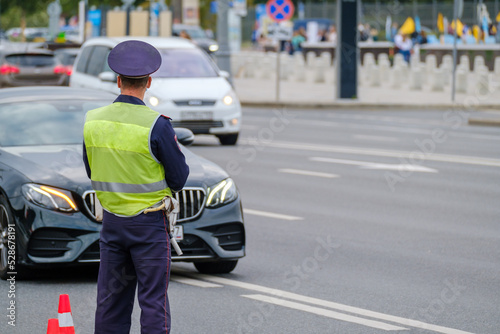 Traffic officer standing near road © Anton Gvozdikov