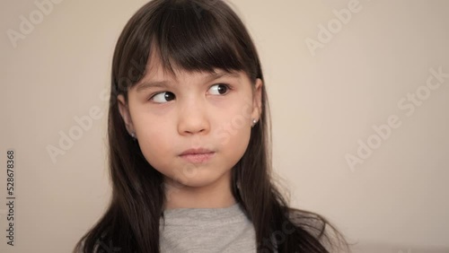 Close up portrait of caucasian little brunette girl in grey shirt smiling look at camera. Adorable kid laughing. Happy childhood concept 
